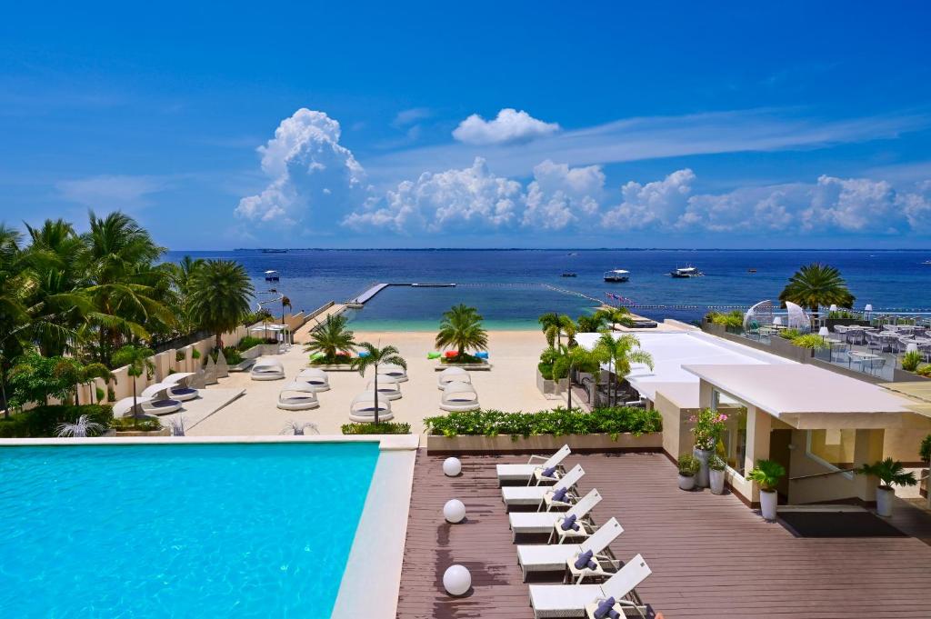 Blick auf ein Resort mit Pool und Strand in der Unterkunft BE Resort Mactan in Mactan