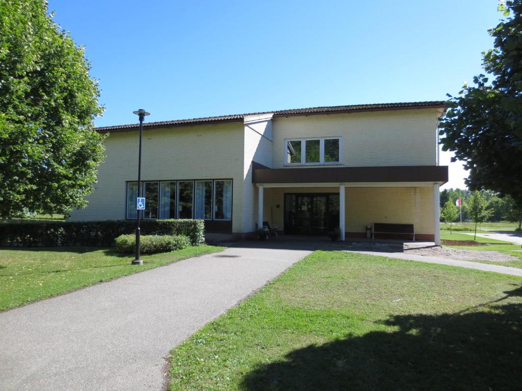 un gran edificio blanco con un camino delante de él en Nygården Stjärnholm en Nyköping