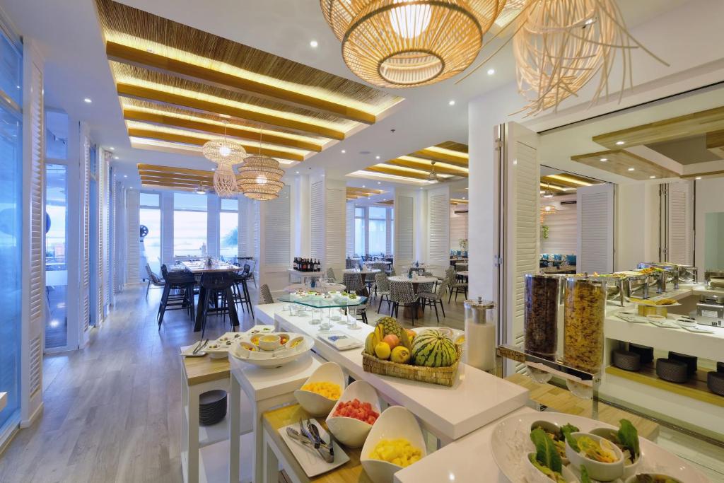 a restaurant with a buffet line with fruit on display at BE Resort Mactan in Mactan