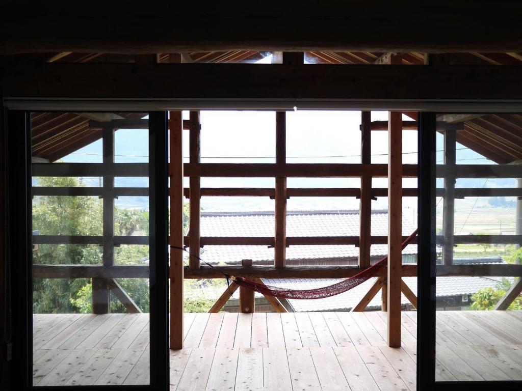 a view from the inside of a building with a hammock at SOCKET in Minami Aso