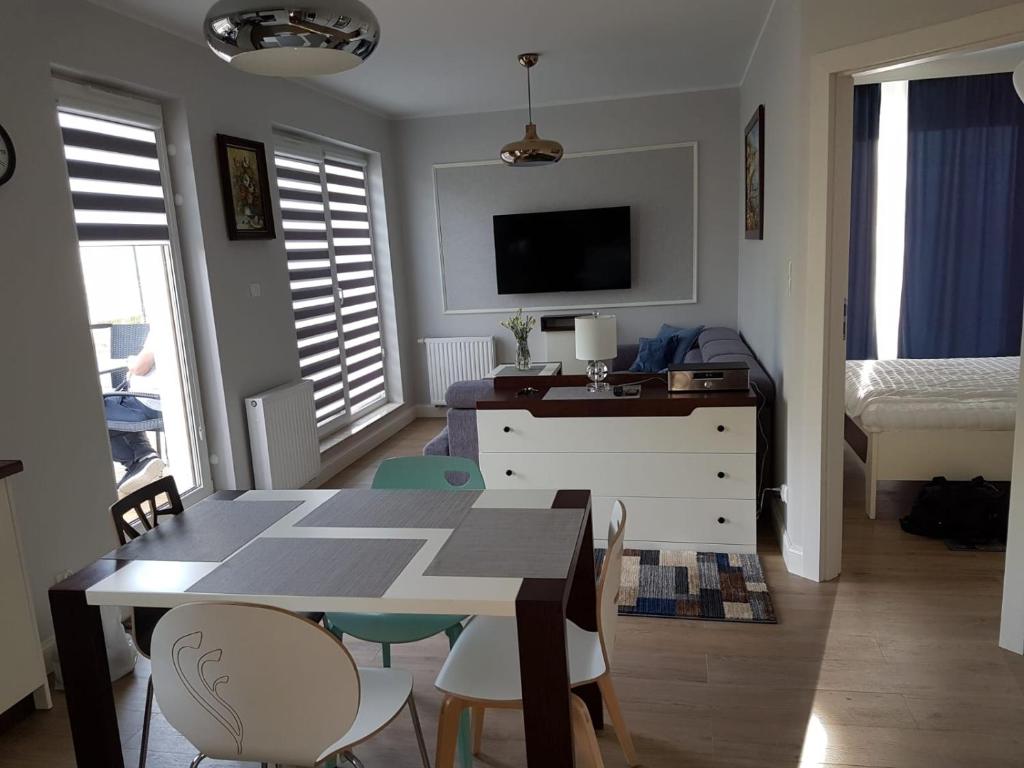 una habitación con mesa y sillas y un dormitorio en u Jolanty, en Jastrzębia Góra