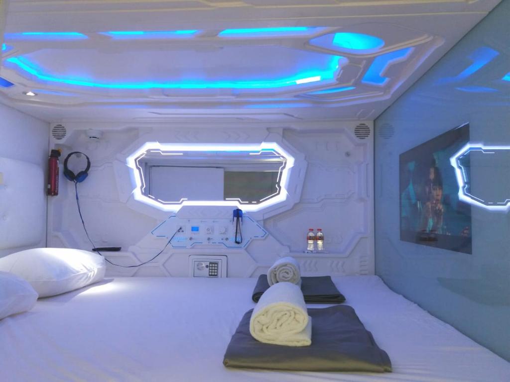 een kamer met een bed met verlichting bij Shakti Capsule Hotel Jakarta in Jakarta