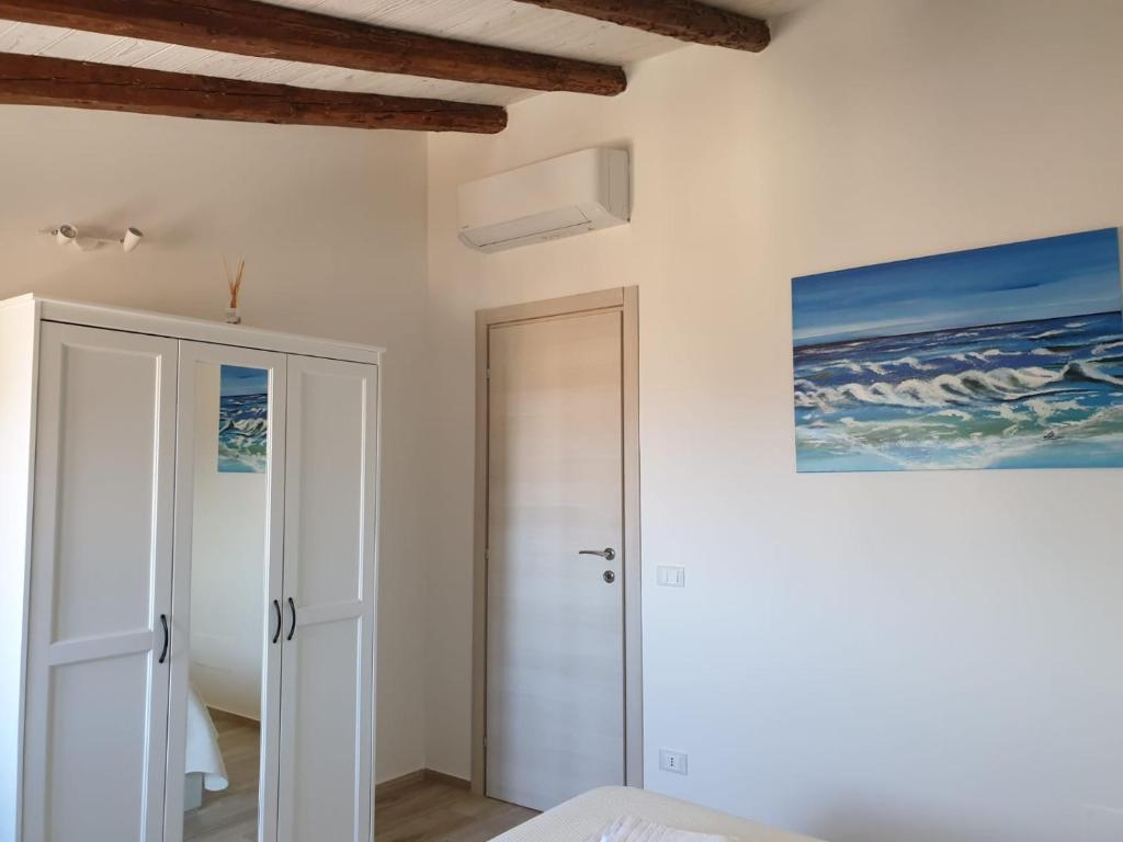 a bedroom with a door and a painting on the wall at DE MEO Guest House in Castellammare del Golfo