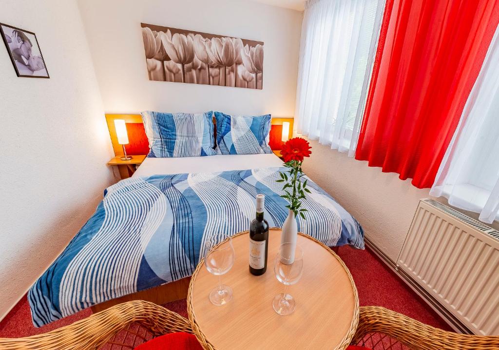 a bedroom with a bed and a table with a bottle of wine at Penzion U Jezku in Blansko