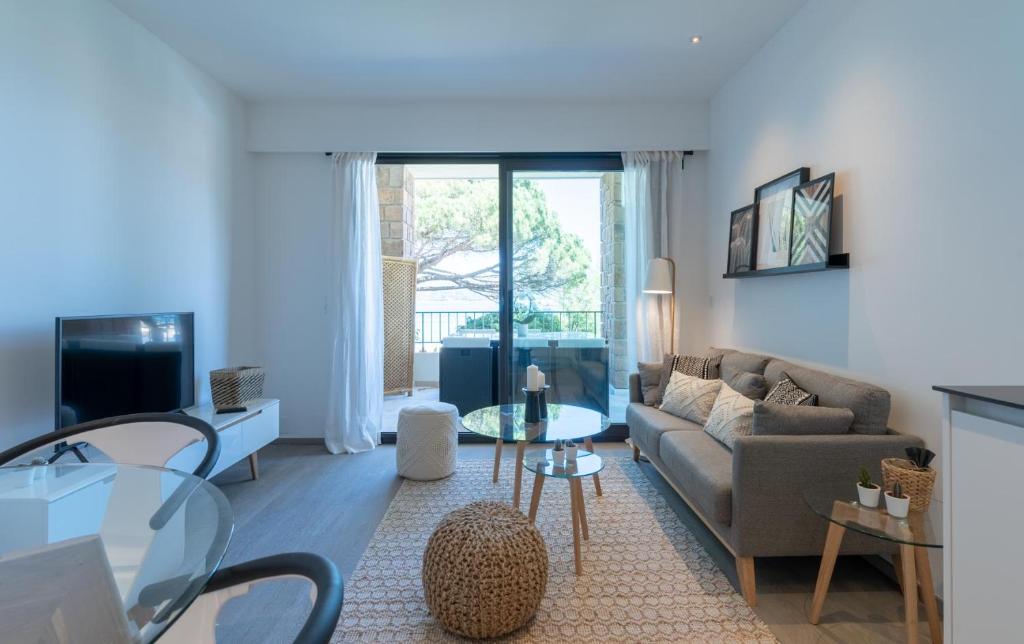 ein Wohnzimmer mit einem Sofa und einem Tisch in der Unterkunft SINFONIA in Saint-Tropez