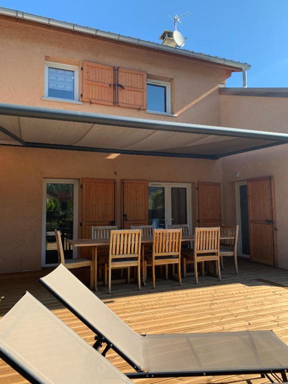a patio with a table and chairs on a deck at Chalet Barcelonnette in Barcelonnette