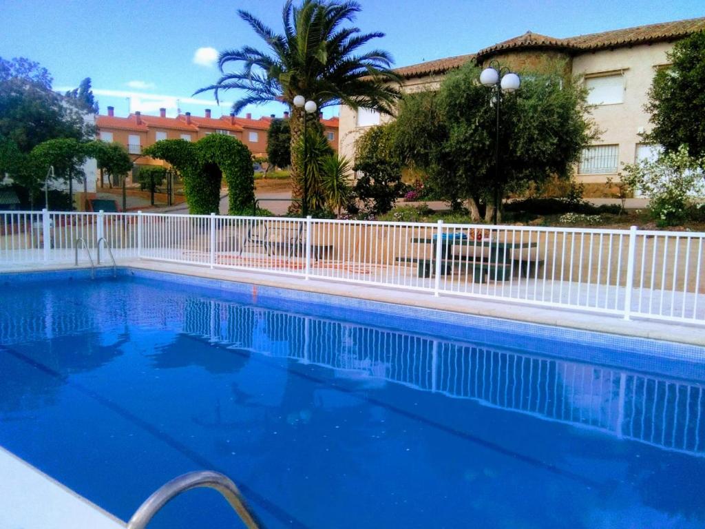 a large blue swimming pool with a white fence at La Casa de Polito in Los Navalucillos