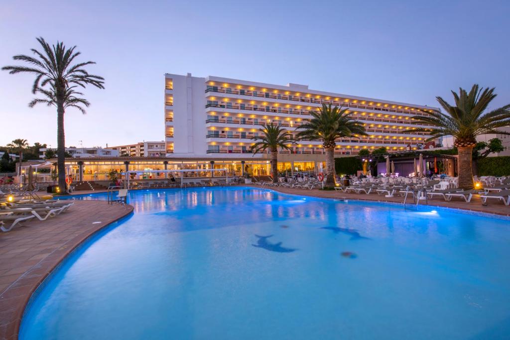 a large swimming pool in front of a hotel at Hotel Caribe in Es Cana