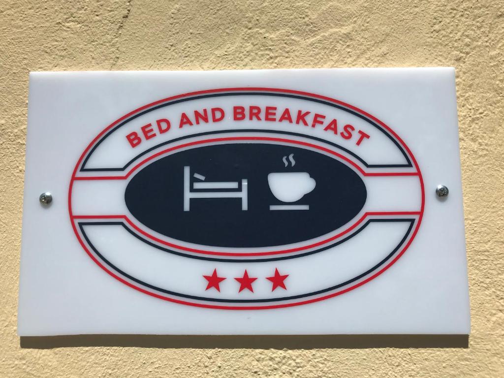 um sinal para um alojamento de acomodação e pequeno-almoço numa parede em B&B Hibiscus em Capoterra