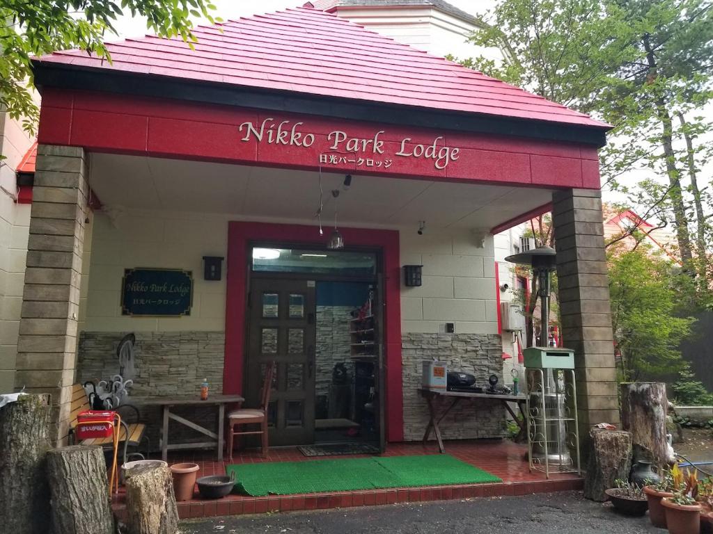 un restaurant avec une porte rouge et un panneau. dans l'établissement Nikko Park Lodge Mountain Side, à Nikkō