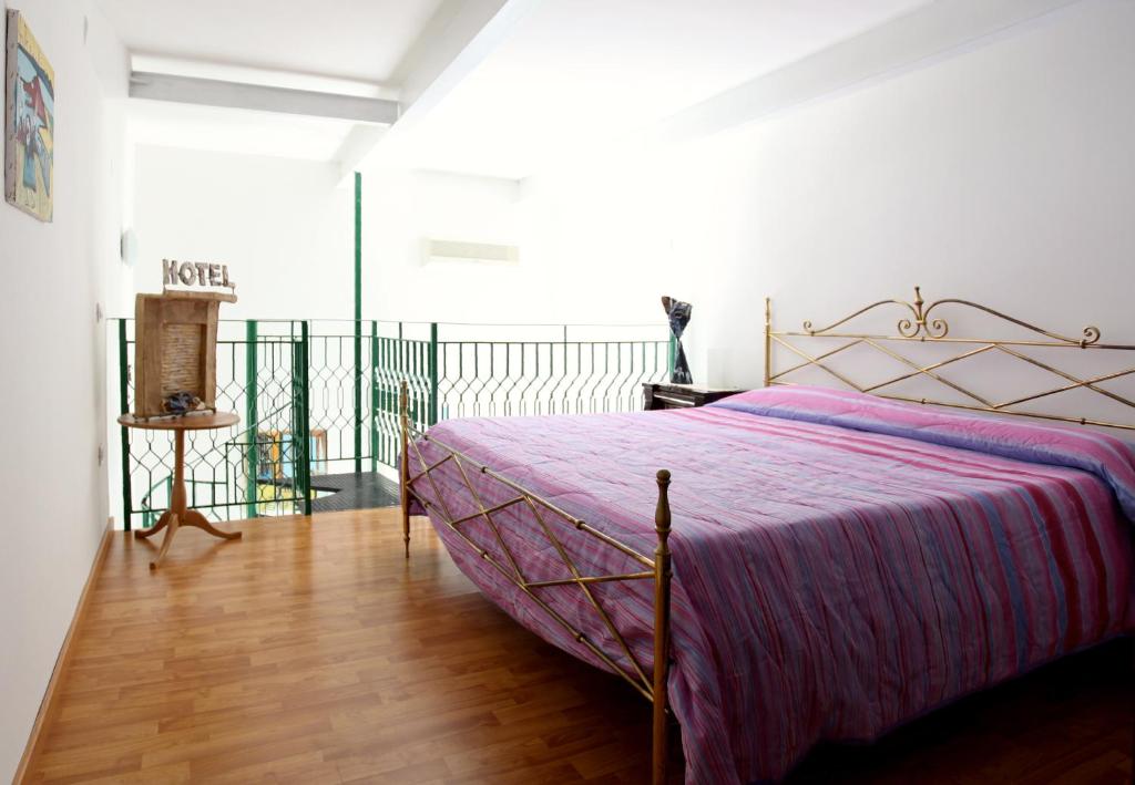 ナポリにあるDormidaMèのベッドルーム1室(紫色のベッドカバー付)