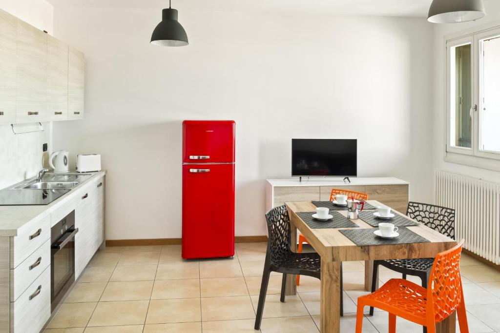 a kitchen with a red refrigerator and a table with chairs at Borgo Sole Cittadella in Cittadella