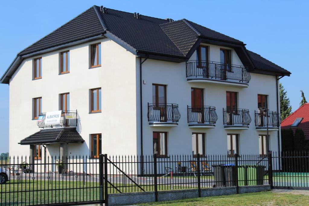 a white house with a black roof at Albatros in Gąski