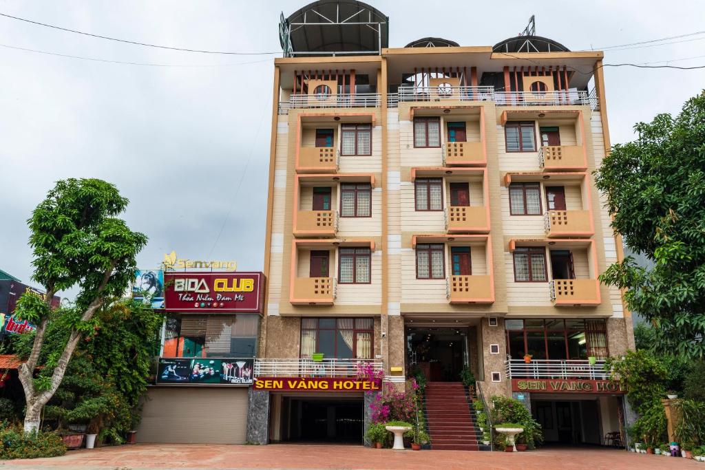 un bâtiment avec une enseigne devant lui dans l'établissement KHÁCH SẠN SEN VÀNG, à Lào Cai