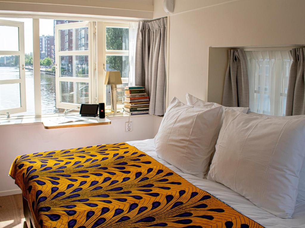 a bedroom with a bed with a black and yellow blanket at SWEETS - Van Hallbrug in Amsterdam