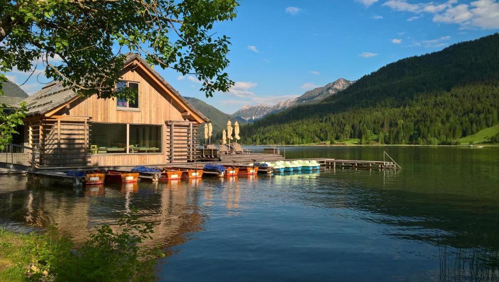 a house on a dock on a lake at Strandhotel am Weissensee in Weissensee