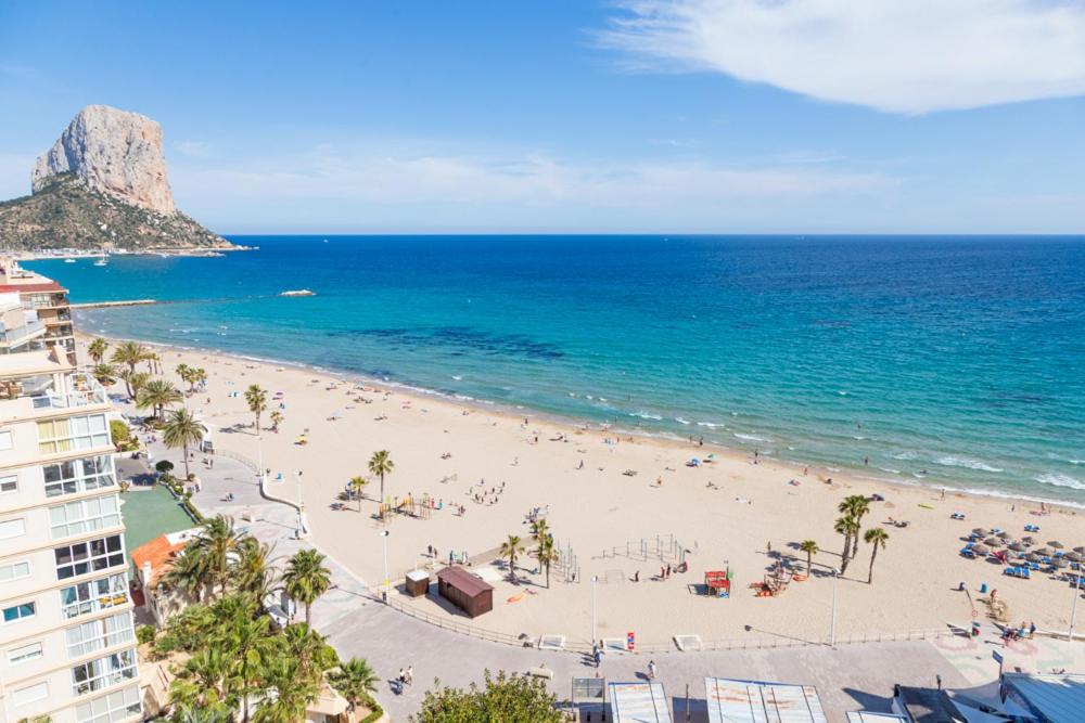 una playa con mucha gente y el océano en Apartamentos Colón - Grupo Antonio Perles, en Calpe