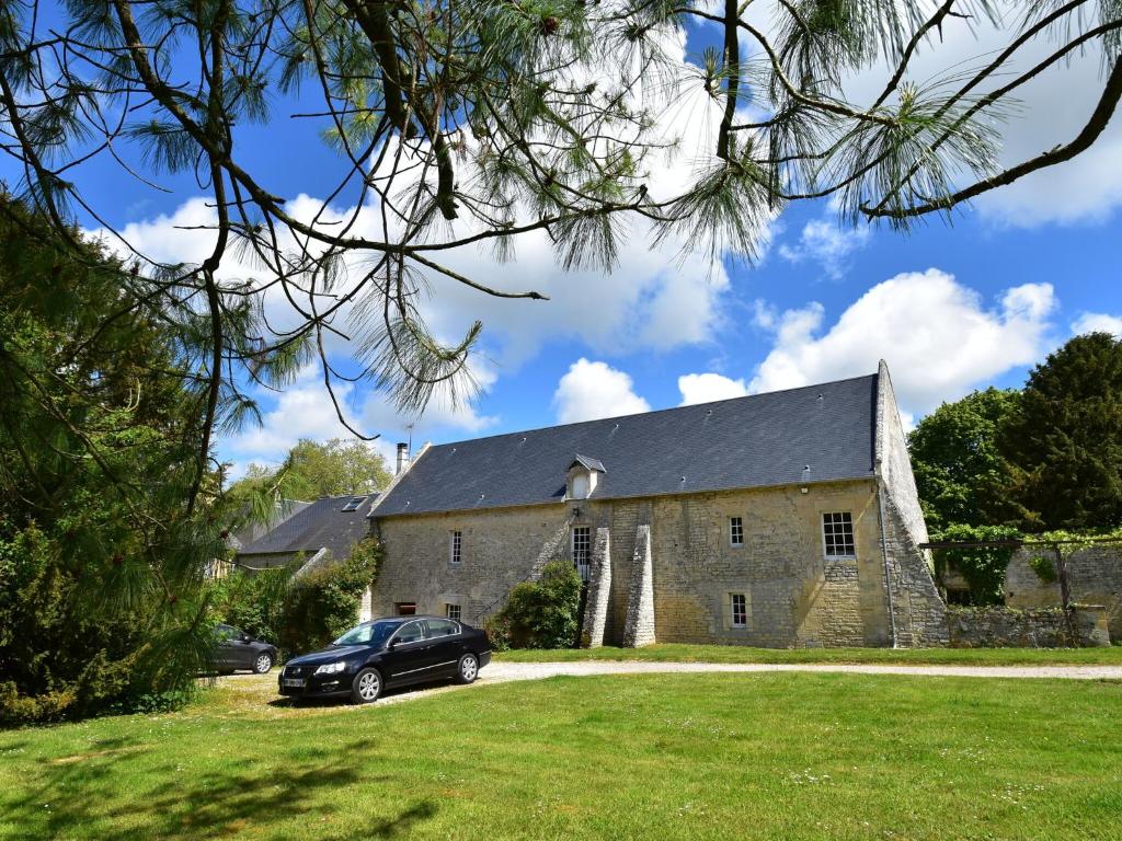 LantheuilにあるCozy Holiday Home in Lantheuil with Gardenの石造りの教会前に停められた車