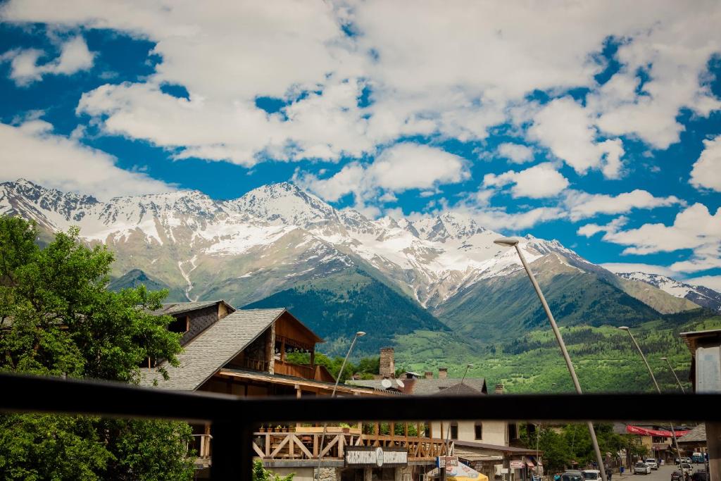 a view of snow covered mountains from a town at Chalet Mestia in Mestia
