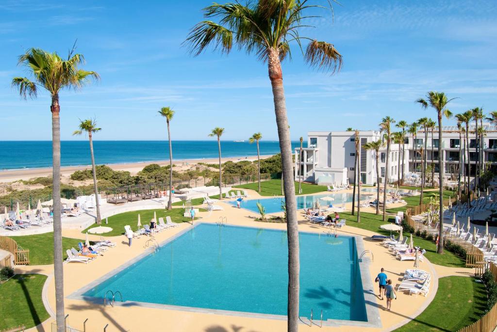 an aerial view of a resort with a swimming pool and the beach at Hipotels Barrosa Park in Chiclana de la Frontera
