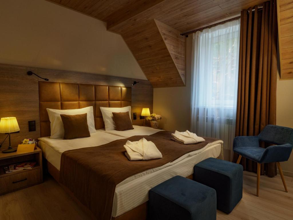 a bedroom with a large bed and two blue chairs at SPA Hotel Veranda in Smolensk