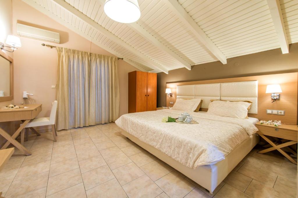 - une grande chambre avec un grand lit et un bureau dans l'établissement Hotel Plessas Palace, à Alikanas