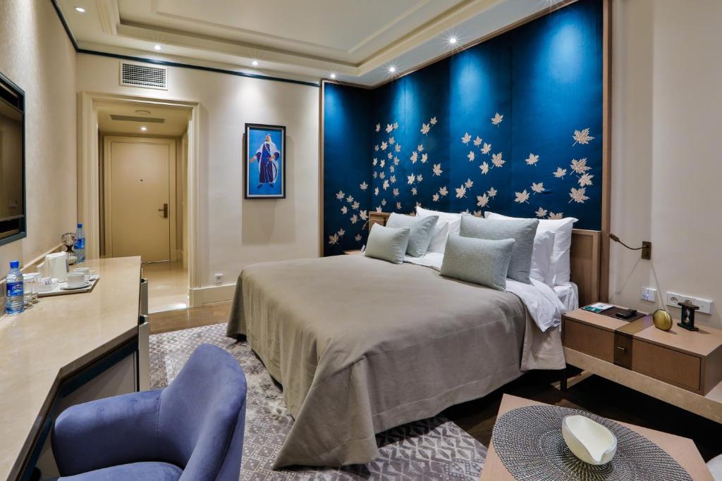 1 dormitorio con 1 cama grande y pared azul en Dreamland Golf Hotel Baku en Baku