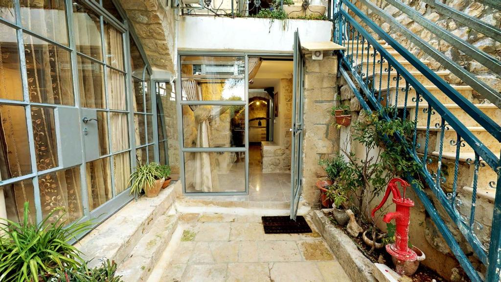 wejście do starego budynku z czerwonym hydrantem pożarowym w obiekcie HEMDAT NEFESH w mieście Safed