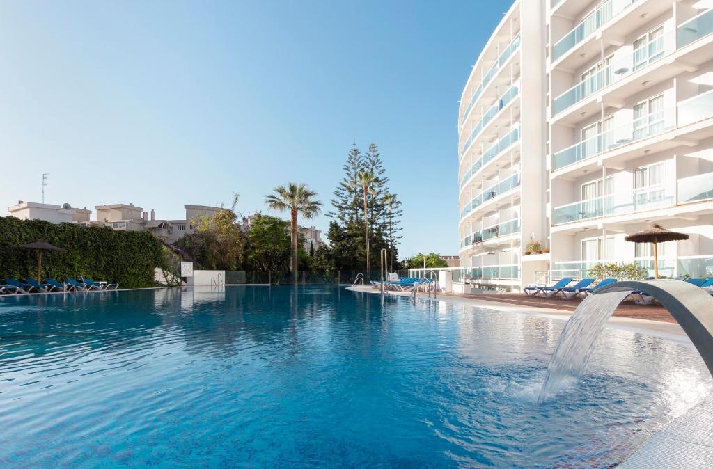 a large swimming pool in a large city at Hotel Palia Las Palomas in Torremolinos