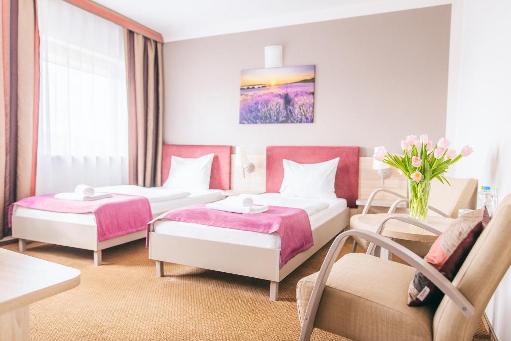 a hotel room with two beds and a couch at Hotel Forum in Rzeszów
