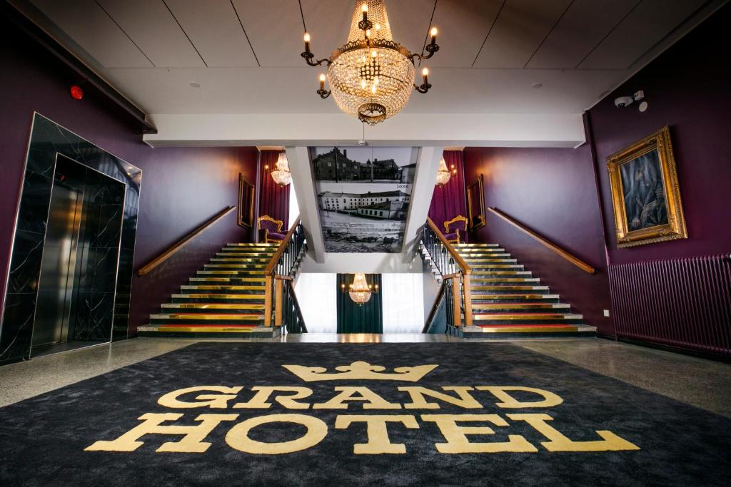 um grupo de escadas com um grande tapete de hotel no chão em Grand Hotel Mustaparta em Tornio