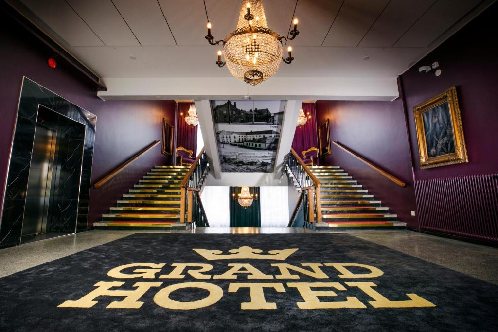 a group of stairs with a grand hotel rug on the floor at Grand Hotel Mustaparta in Tornio