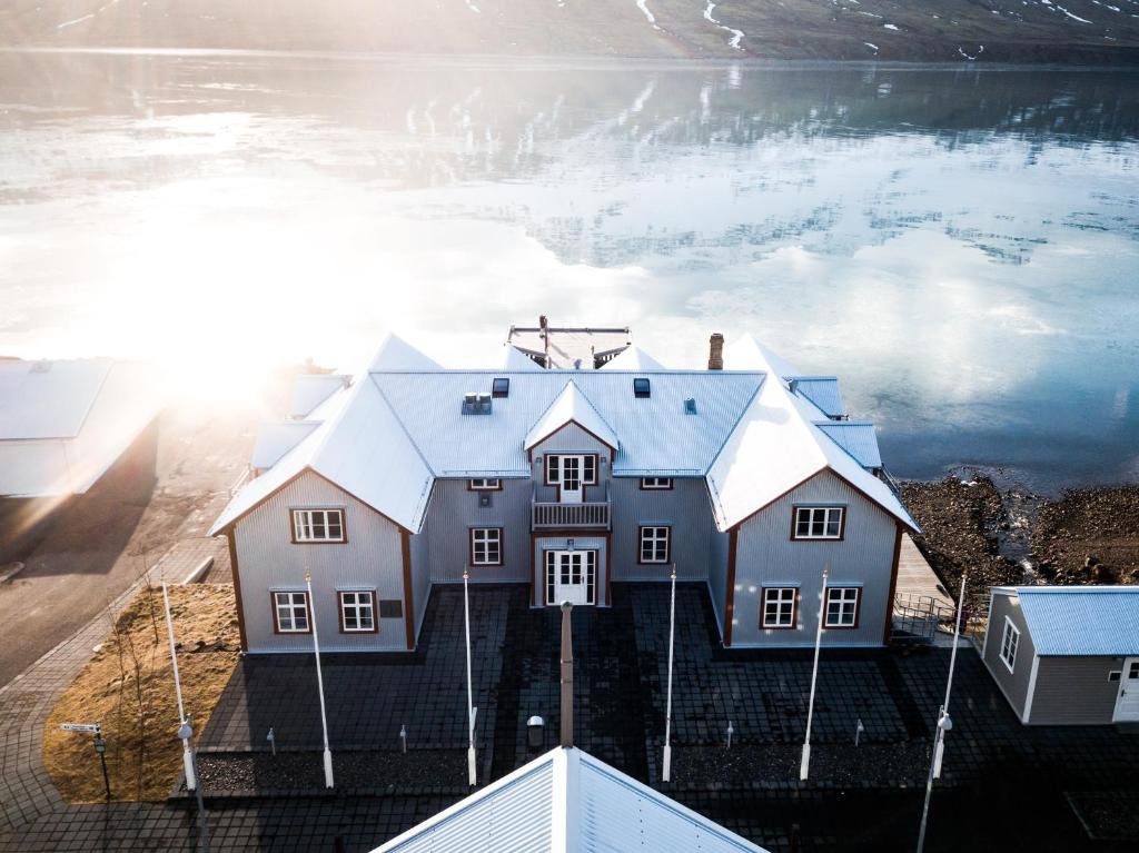 an aerial view of a house next to a body of water at Fosshotel Eastfjords in Fáskrúðsfjörður