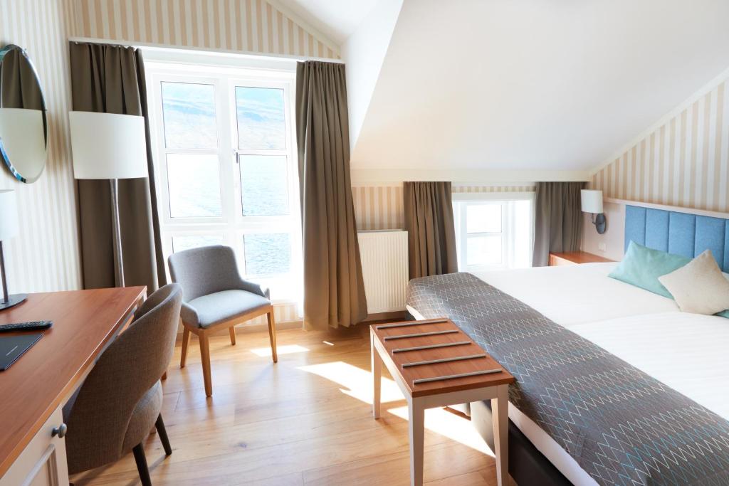 a hotel room with a bed and a desk at Fosshotel Eastfjords in Fáskrúðsfjörður