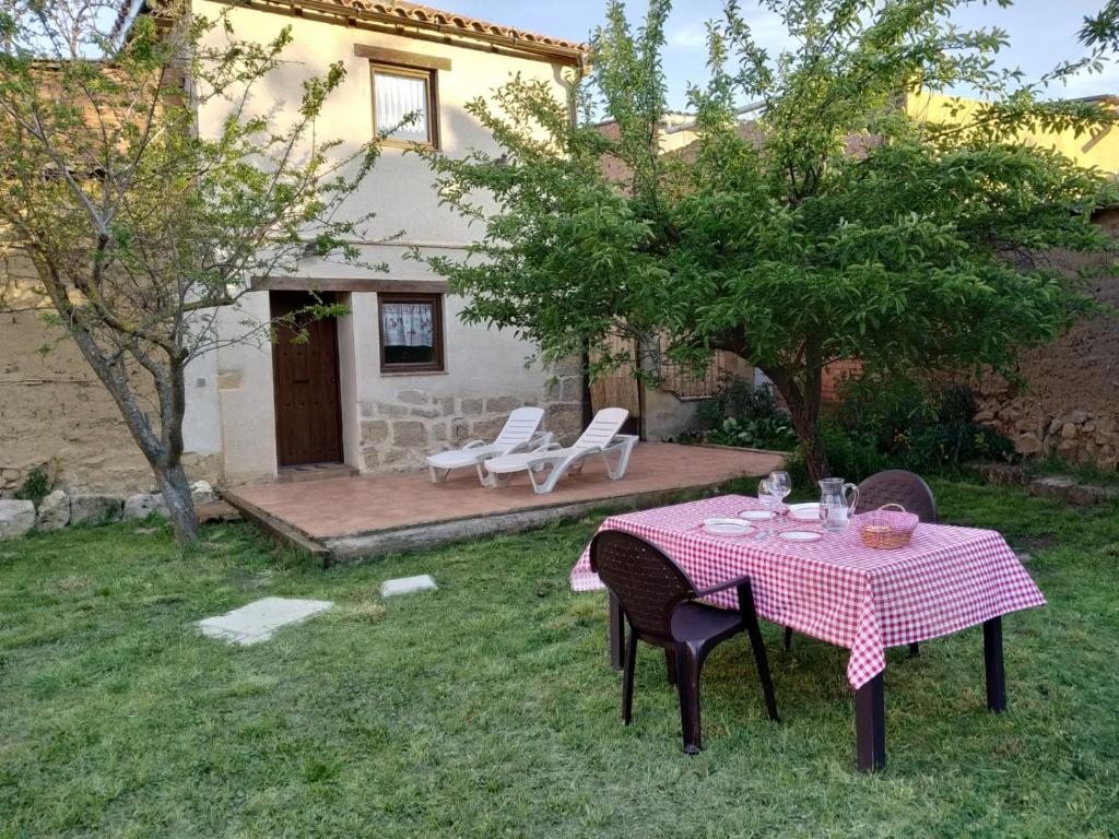 una mesa y sillas en el patio de una casa en La casa de los abuelos lugar para disfrutar en Amusco