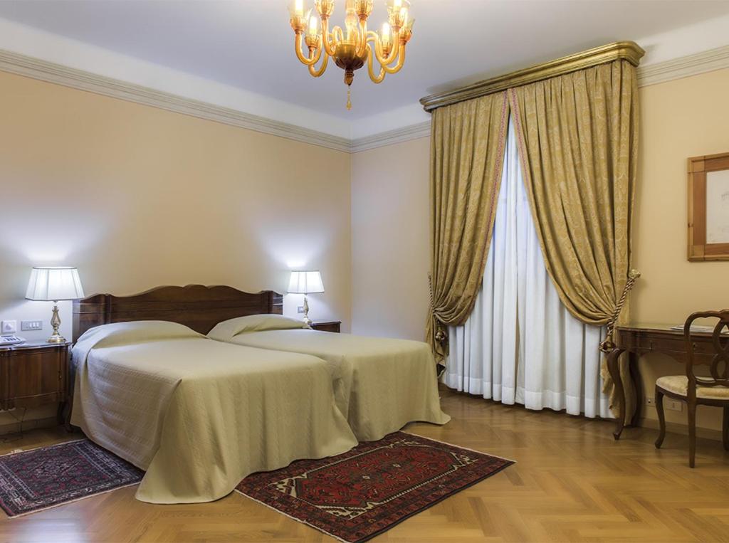 En eller flere senger på et rom på Villa Fenaroli Palace Hotel