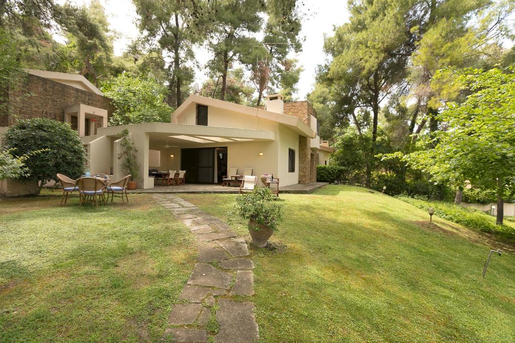 a house with a patio and a grass yard at #FLH - Mediterrané Pool Villa 2 in Sani Beach