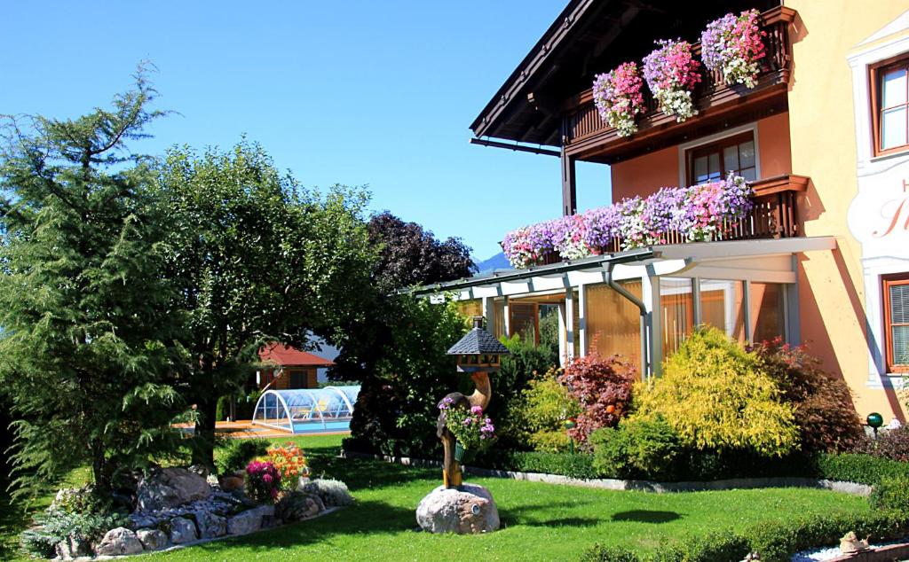 a house with flowers in the front yard at Gästehaus Steiner in Tröpolach