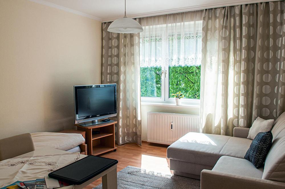 ein Wohnzimmer mit einem Sofa und einem TV in der Unterkunft Apartment am Bahnhof in Salzburg