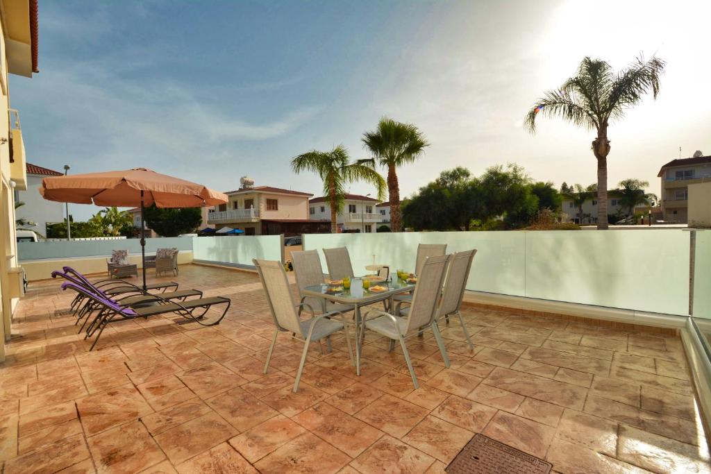 a patio with a table and chairs on a balcony at Nissi Martha Apartment in Ayia Napa