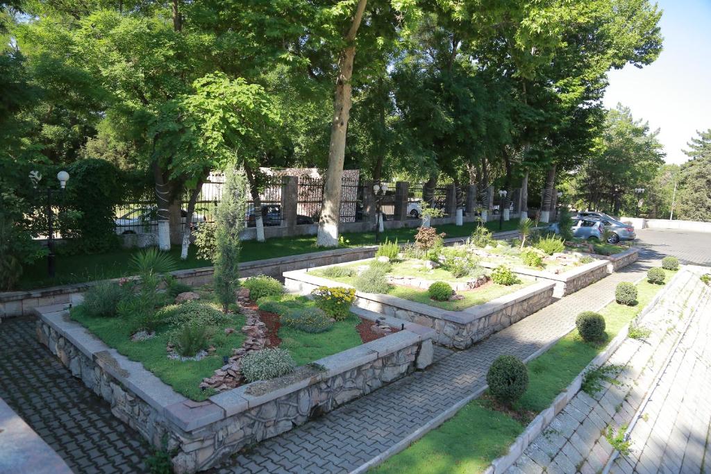 a garden with plants and trees in a park at Shodlik Palace in Tashkent