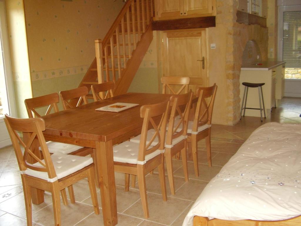 una mesa de comedor de madera y sillas en una habitación en La Petite Maison, en Clavy-Warby