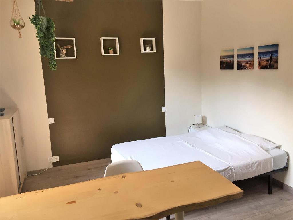 um quarto com uma cama e uma mesa e quadros na parede em MON FARE em Argelès-sur-Mer