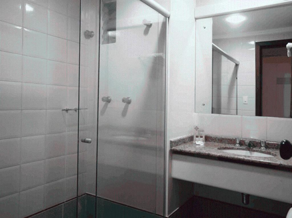 a glass shower in a bathroom with a sink at Portal da Princesa Hotel in Feira de Santana