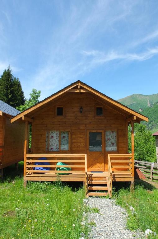 a log cabin with two benches in front of it at Mountain Cabins in Mestia