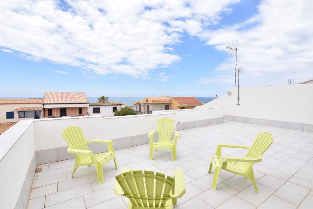 a patio with two chairs and two chairs on a roof at Casa del Mar in Marina di Ragusa