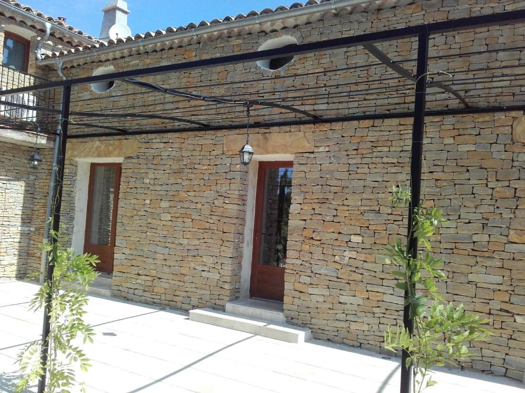 - un bâtiment en briques avec une porte rouge dans l'établissement Appartement Domaine l'Oliveraie, au Castellet