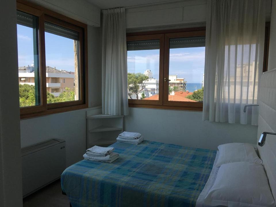 リッチョーネにあるHotel Saint Tropezのベッドルーム1室(ベッド1台、窓2つ付)