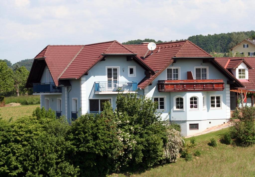 ein großes weißes Haus mit rotem Dach in der Unterkunft Glatz Haus Siegesbrunn in Bad Waltersdorf