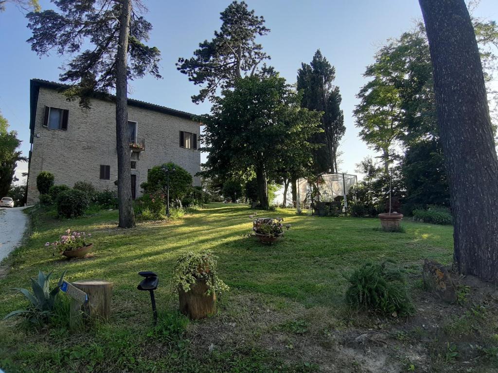 un patio con una casa y algunas plantas y árboles en Ca'Lavalle B&B, en Urbino